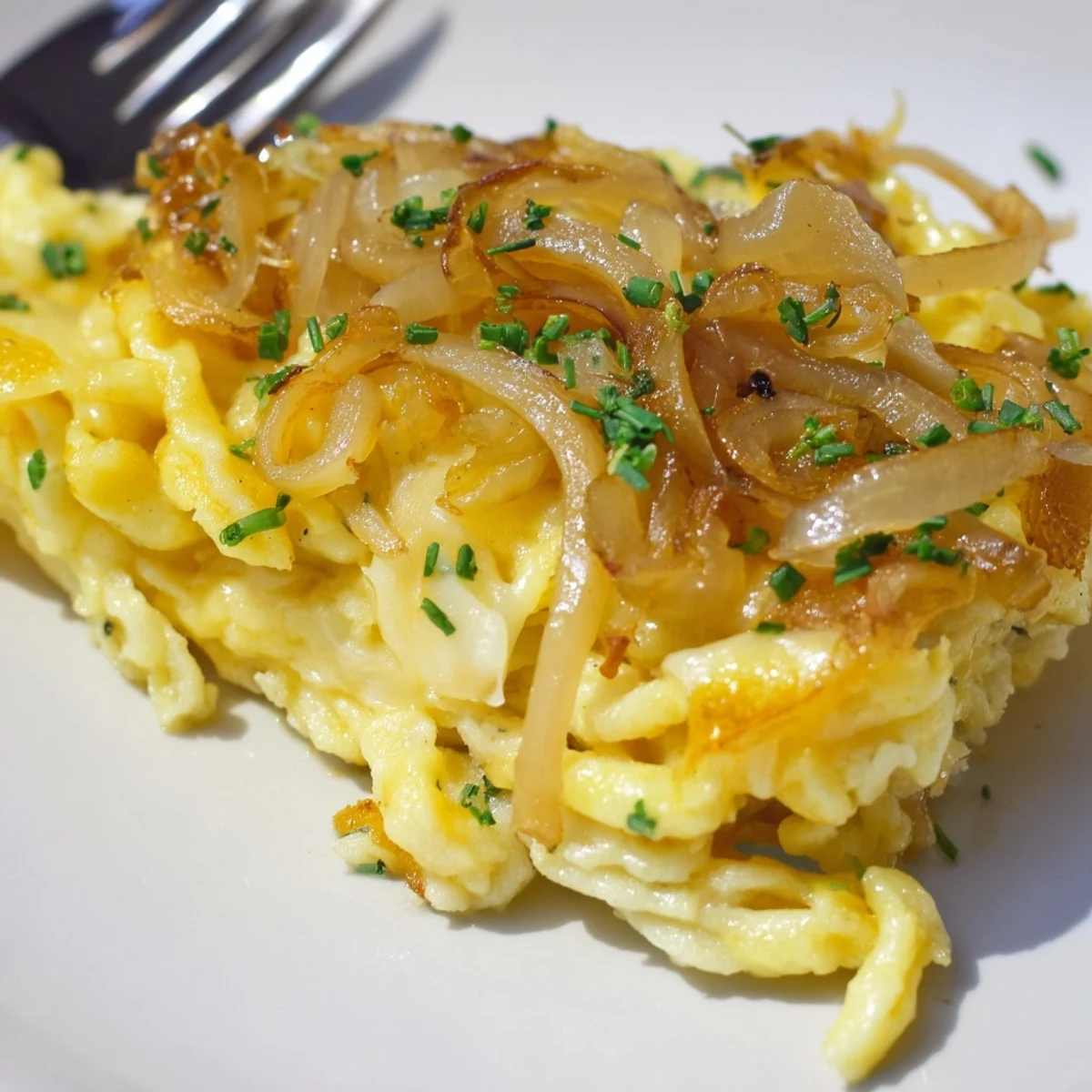 Schmackhafte Käse-Spätzle mit goldbraunen Zwiebeln, ideal für herzhafte Mahlzeiten.