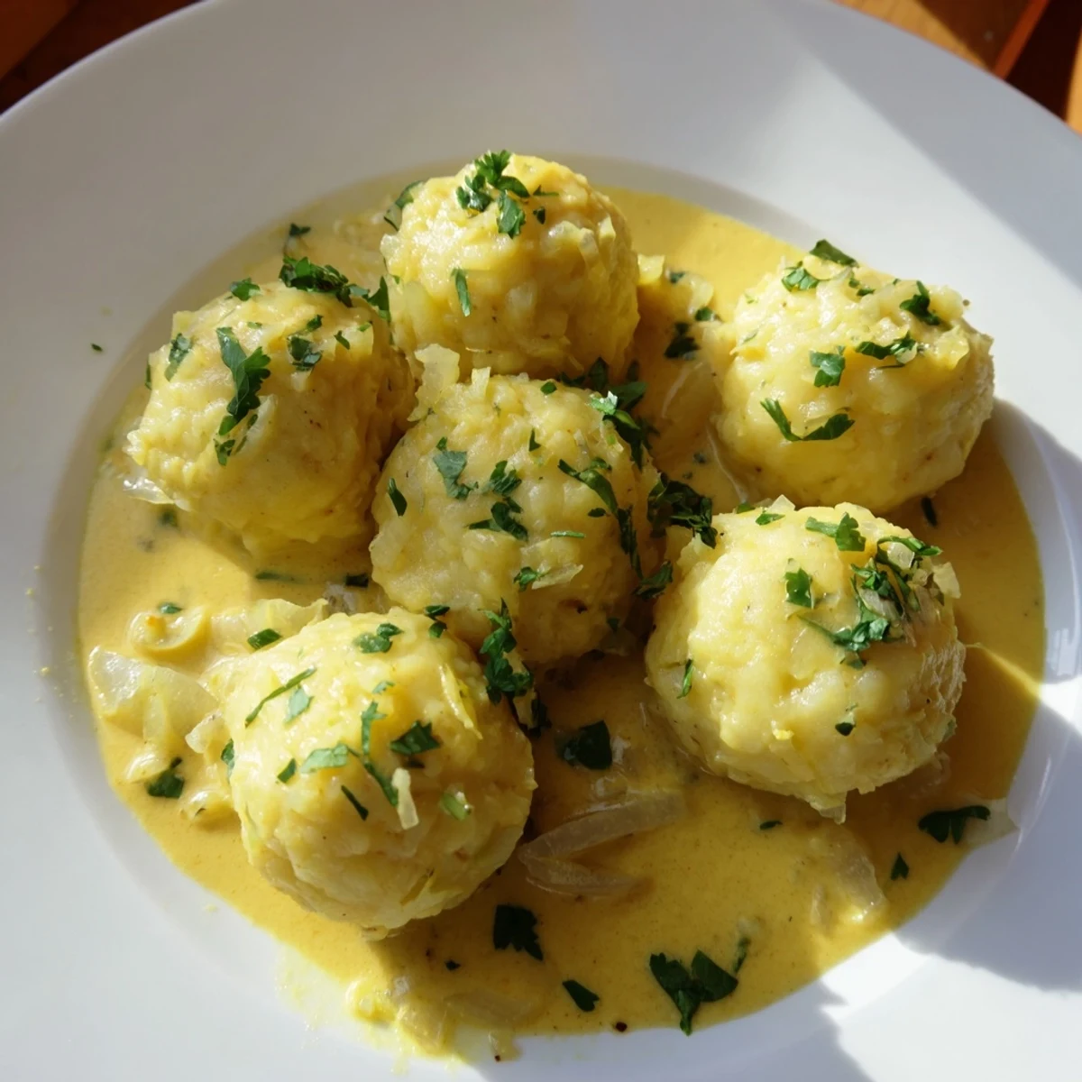 Golden curry cream coats fluffy Curry Comfort Potato Dumplings, garnished with fresh cilantro, ready to enjoy.