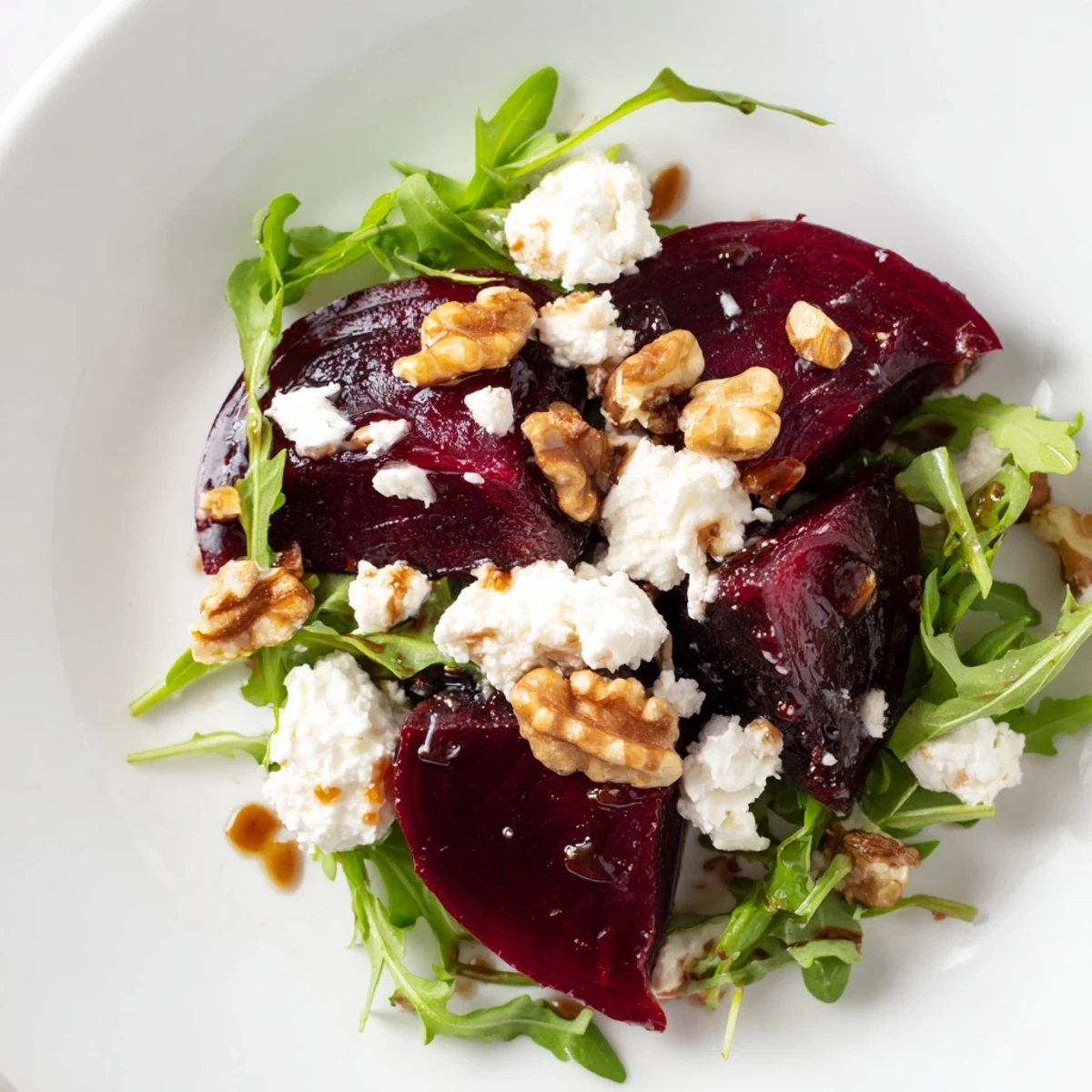 Frisch geröstete Rote Bete auf einem Bett aus knackigem Rucola, ergänzt durch zerbröselten Ziegenkäse und warme Walnüsse mit honigsüßer Balsamico-Note.