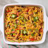 Chicken Burrito Pasta Bake sizzling from the oven, topped with melted cheese and fresh cilantro for a weeknight meal.