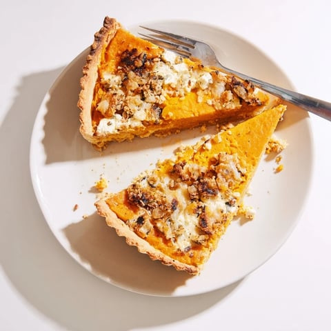 Goldene Savory Pumpkin and Cheese Tart, gefüllt mit cremigem Kürbis und herzhaftem Käse.  