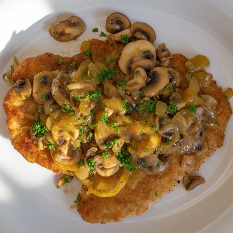 Golden-brown Hunters Schnitzel topped with creamy mushroom gravy, a classic German dish.