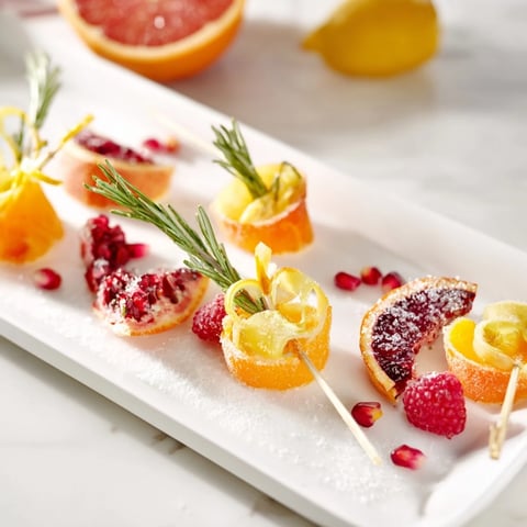 Golden cocktail garnishes: Baisers de Minuit, elegant with vibrant raspberries and chocolate shavings.