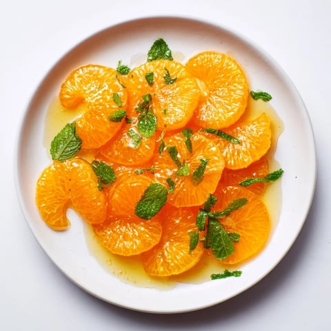 A vibrant winter fruit salad featuring juicy clementines and fresh mint, ready to enjoy.
