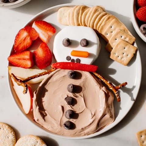 This whimsical Hot Cocoa Dip snowman sparkles with chocolate chips, perfect for a festive occasion.
