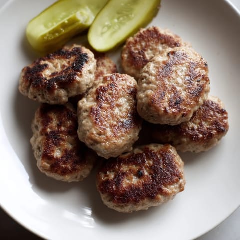 Juicy pan-fried Danish Frikadeller, a classic Danish recipe perfect with tangy pickled cucumbers.