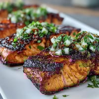 Leuchtend gegrillter Lachs mit fruchtiger Erdbeersalsa und frischem Koriander.